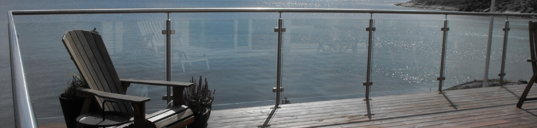 Framed glass balustrades on a decked balcony overlooking open water