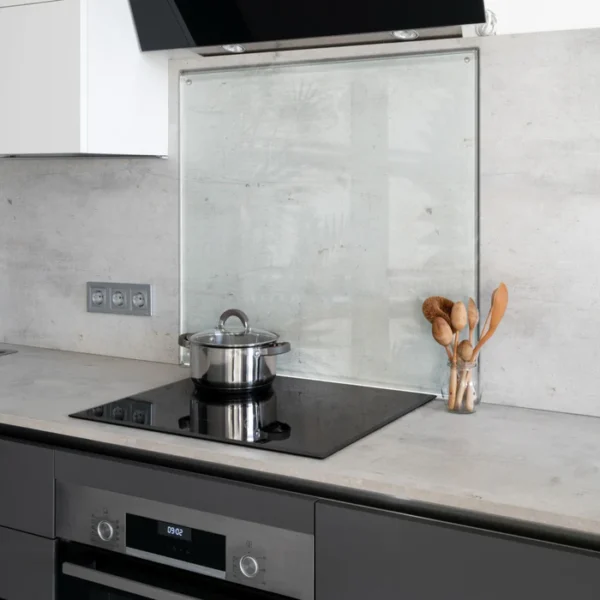 Clear glass kitchen splashback behind a hob